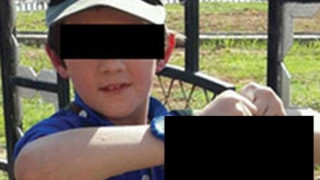 Επτάχρονο παιδί κρατάει ψηλά το κομένο κεφάλι ενος άνδρα.